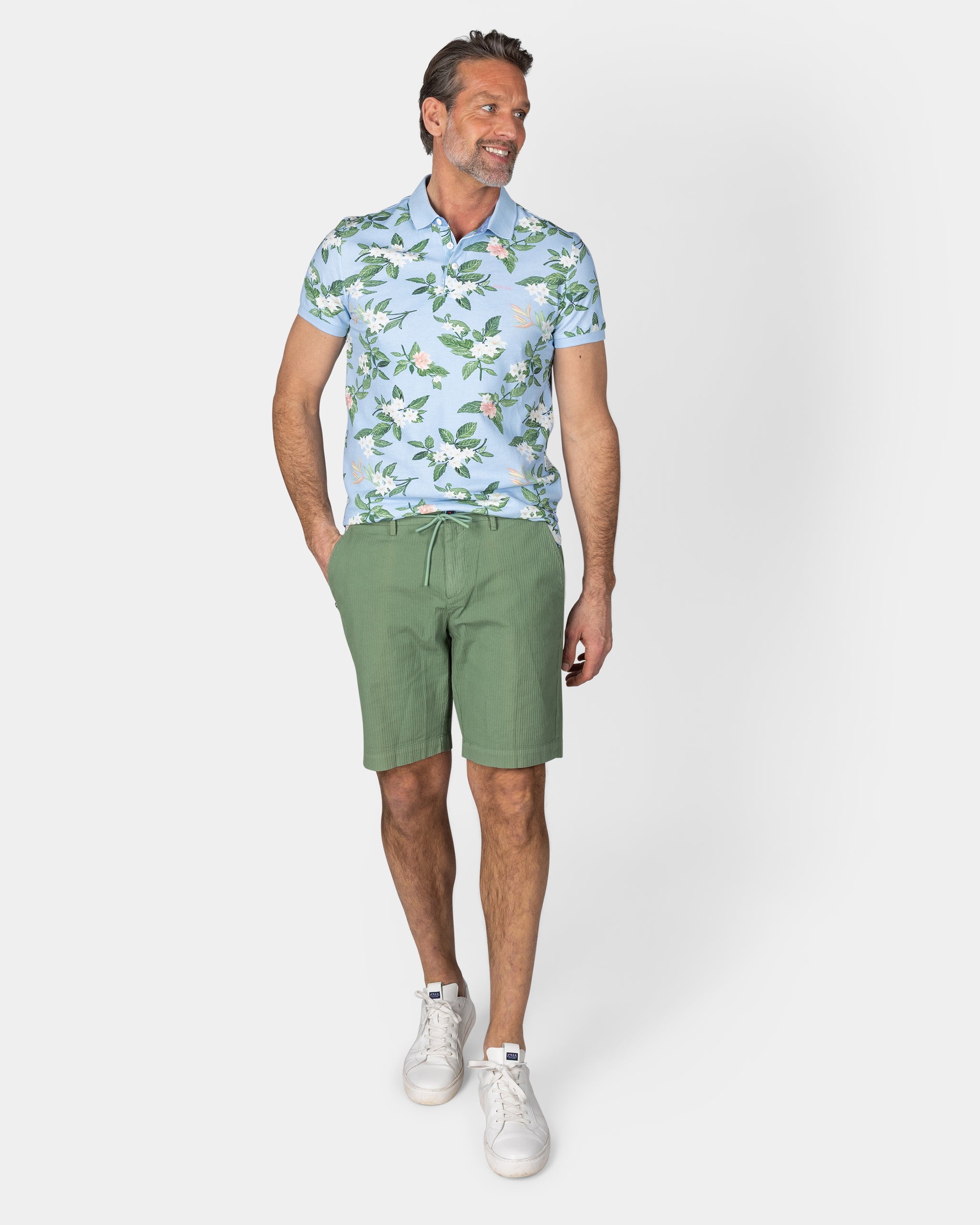 Pastelblauwe polo met grote bloemenprint Pastelblauwe polo met grote bloemenprint
