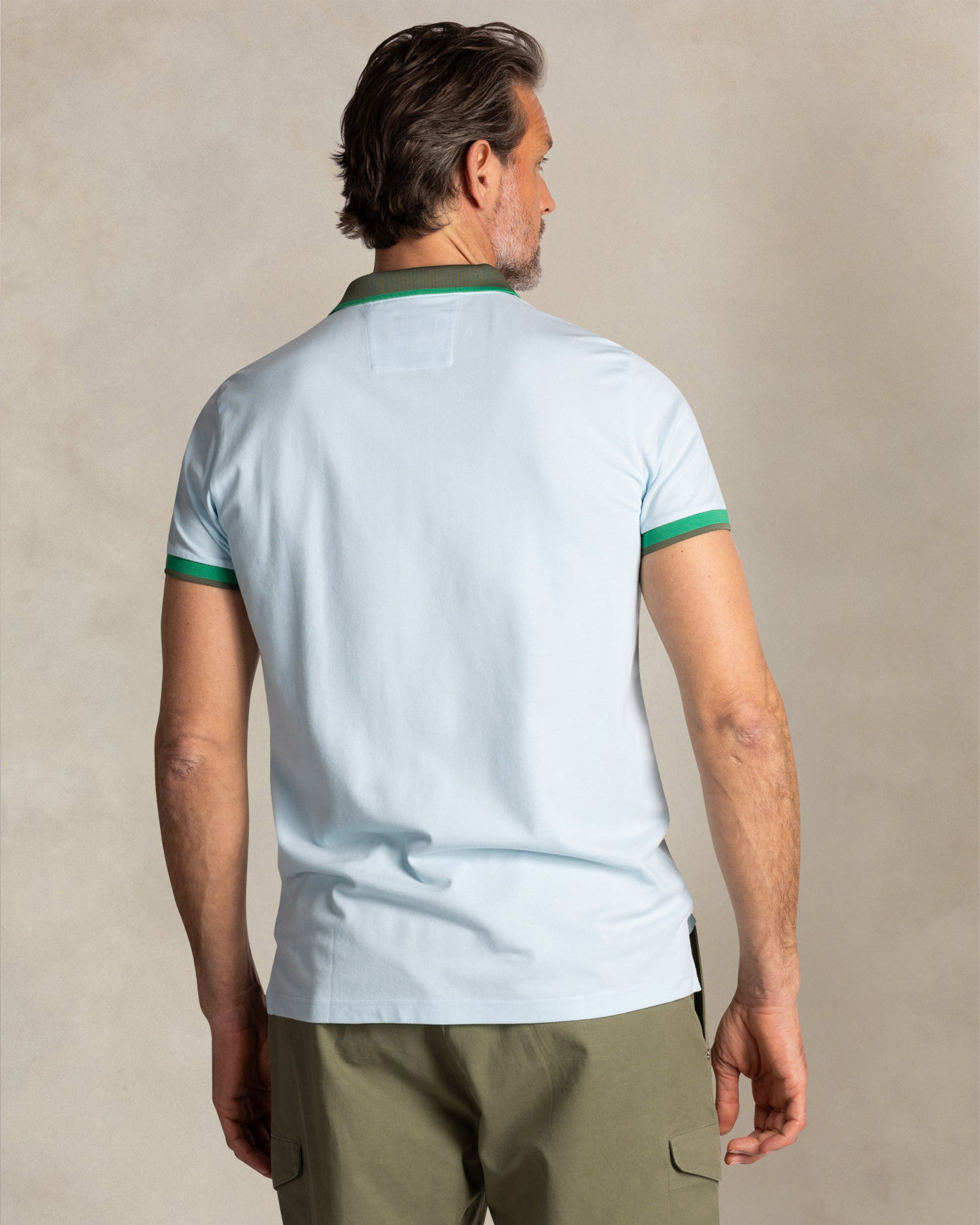 Polo de algodón azul claro con cuello verde Polo de algodón azul claro con cuello verde